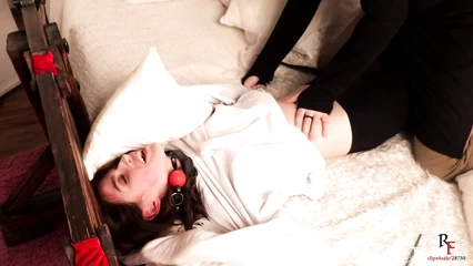 Брюнетку привязали к койке и щекочут перышком