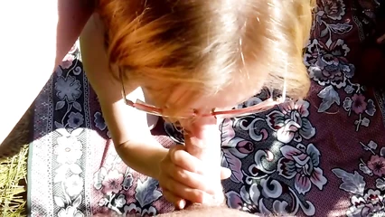 Женщина в очках занимается минетом на природе
